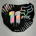 A black motorcycle number plate skin or decal with holographic silver '11' and white Fox Racing graphics, displayed on a white pegboard.