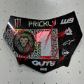 A custom motocross or dirt bike number plate skin decal, featuring a black base with red paint splatters, a green and black leopard print background, a lion graphic, and white text including 'PRICKLY' and 'W9'.