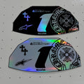 Two black and holographic motorcycle decals with the number 1, featuring Alpinestars and ECU Battery branding, displayed on a white pegboard.